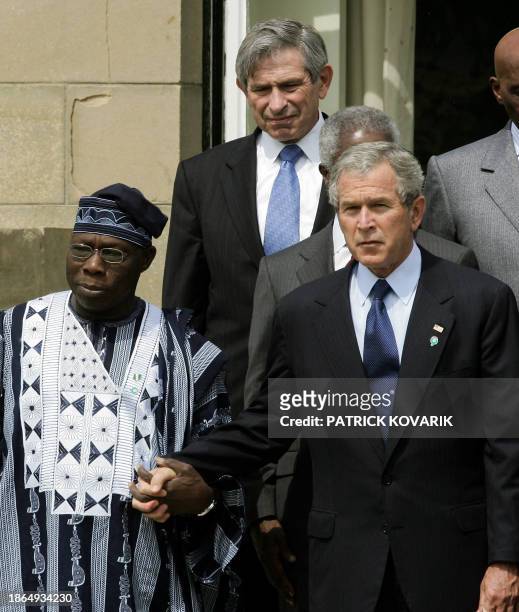 President George W. Bush holds Nigerian President Olusegun Obasanjo's hand during a family picture of a G8 summit 08 July 2005, in Gleneagles. The...
