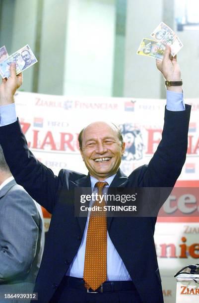 Romanian President Traian Basescu displays bills of the new Romanian currency, the leu, 01 July 2005 during a ceremony marking its introduction in...