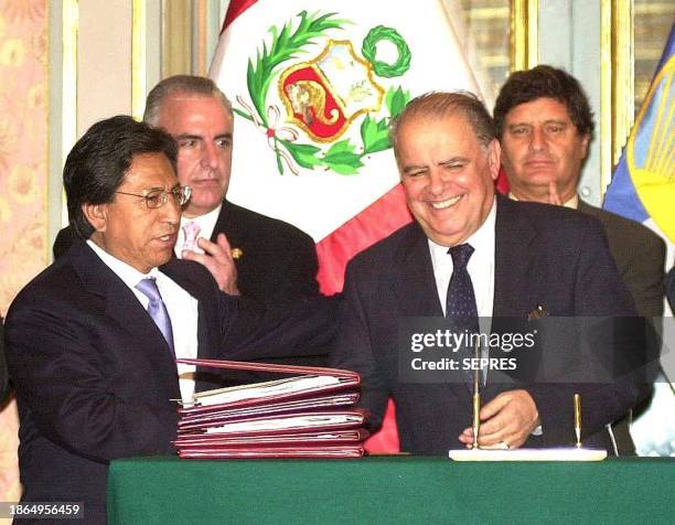 Peruvian President Alejandro Toledo , shakes hands with the International Development Bank President, Enrique Iglesias , moments after singing a...