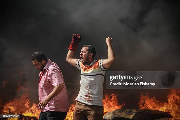 Supporter of ousted president Mohamed Morsi gestures during the violent dispersal of Rabaa Adaweya camp by security forces on August 14th, 2013. More...