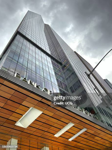 Low angle view of Bank of America Tower against ominous grey sky, New York City, New York, USA.