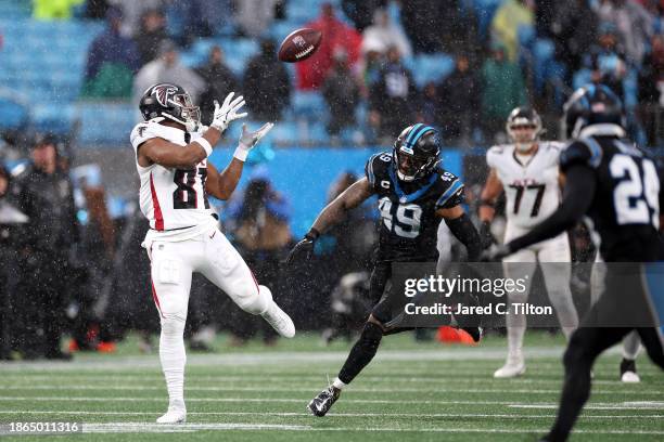 Jonnu Smith of the Atlanta Falcons makes a catch as he is defended by Frankie Luvu of the Carolina Panthers during the first half of the game at Bank...