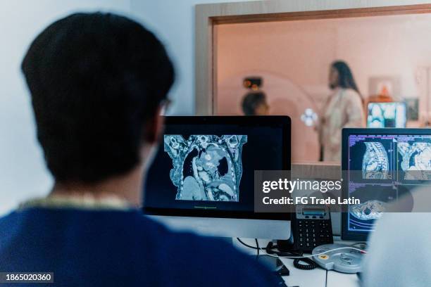 male nurse analyzing medical x-ray in tomography at hospital - real life science stock pictures, royalty-free photos & images