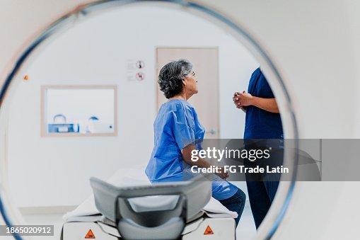 Senior woman talking to a nurse on a MRI tomography at hospital Senior woman talking to a nurse on a MRI tomography at hospital