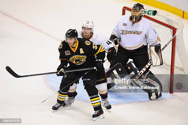 Patrice Bergeron of the Boston Bruins screens Cam Fowler and Jonas Hiller of the Anaheim Ducks at the TD Garden on October 31, 2013 in Boston,...