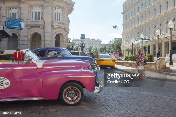 Havana, Cuba, Two vintage classic cars wait for tourists outside the Floridita Bar and Restaurant in Old Havana. .