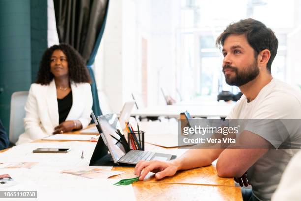 portrait of mixed race couple working together attending on meeting table with technology. - mixed race young creatives in meeting stock-fotos und bilder