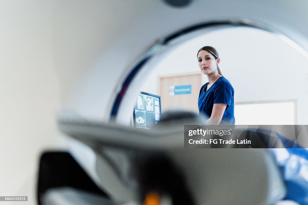 Retrato de uma enfermeira preparando paciente para exame tomográfico em hospital hospitalar