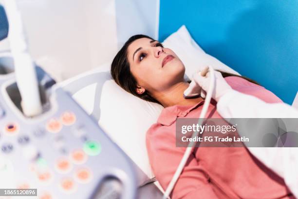 mittlere erwachsene frau bei ultraschalluntersuchung im krankenhaus - schilddrüsenüberfunktion stock-fotos und bilder