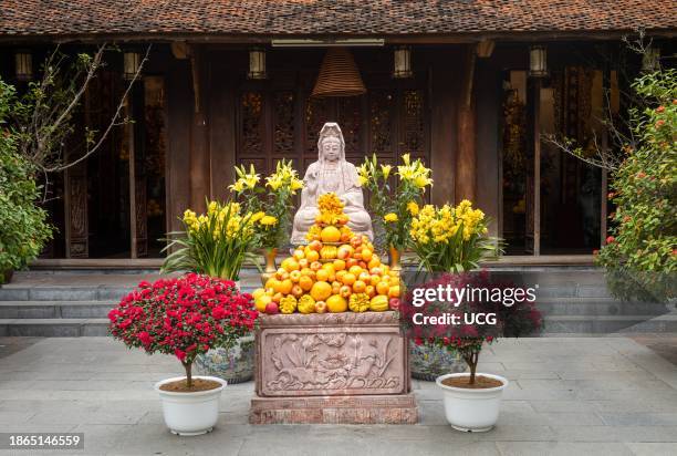Buddhist shrine decorated with flowers and fruit in front of Dien Huu Pagoda next to One Pillar Pagoda, in Hanoi, Vietnam.