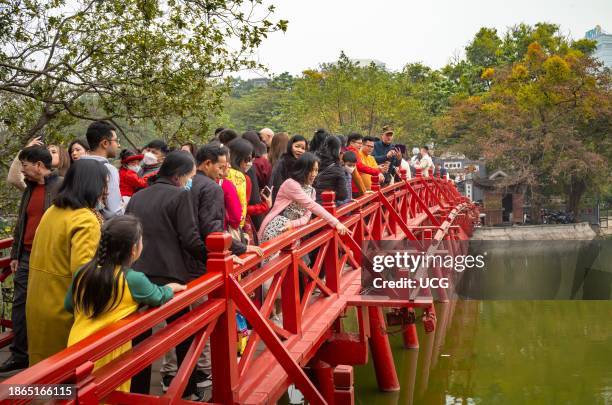 Vietnamese people crowd across The Huc bridge to Ngoc Son Temple on Hoan Kiem lake in Hanoi, Vietnam, on the first day of Tet, or lunar new year.
