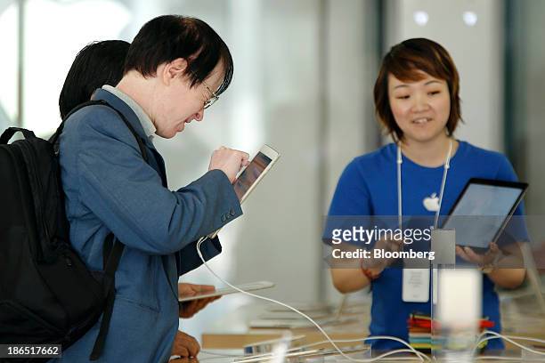 Customer tries out an Apple Inc. IPad Air at the company's store in the Ginza district of Tokyo, Japan, on Friday, Nov. 1, 2013. Apple Inc.'s...