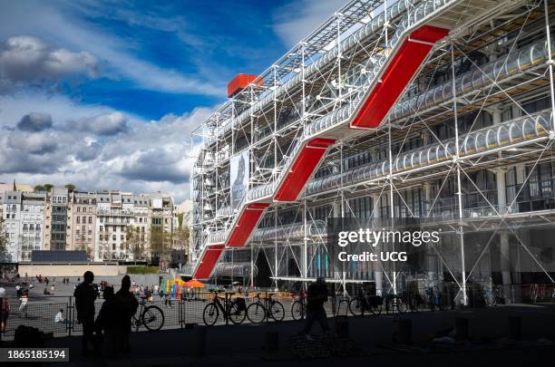 Bicycles and street vendors silhouetted next to the modernist Pompidou Centre, and Place Georges Pompidou in Paris, France.