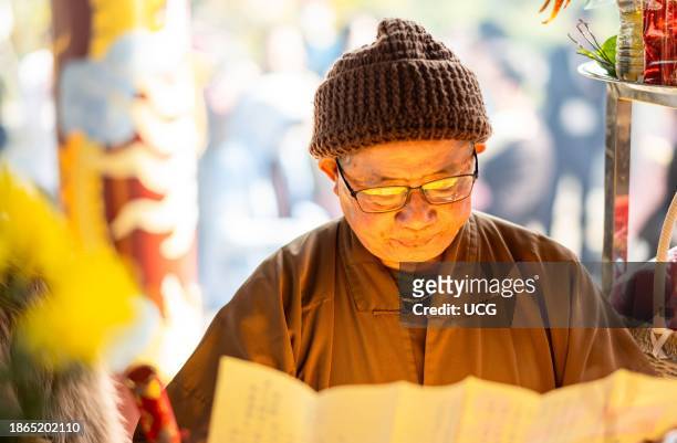 Vietnamese Buddhist monk prays at lunar new year at the 17th century Buddhist Cua Ong Temple, in Cam Pha, Quang Ninh, Vietnam. It is dedicated to...