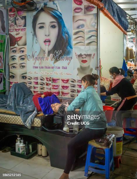 Vietnamese woman has her hair washed in a small hair salon within the market in Mong Cai, Quang Ninh, Vietnam.