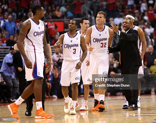 DeAndre Jordan of the Los Angeles Clippers is intercetped by Chris Paul, Blake Griffin, and head coach Doc Rivers after Jordan got in an altercation...