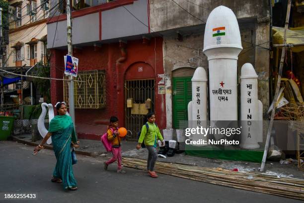 Children are walking past a Styrofoam figure of ISRO's rocket for Chandrayaan 3, which is on display as part of Christmas decorations, as seen at a...