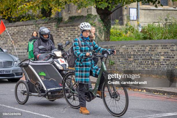 mother with a child in a bicycle trailer - cambridgeshire imagens e fotografias de stock
