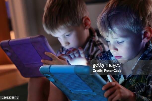 two young boys looking at computer tablets - staring at screen stock pictures, royalty-free photos & images