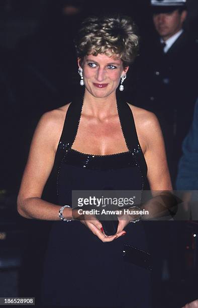 Diana, Princess of Wales, wearing a black halter-neck evening gown with bugle beads designed by Catherine Walker, attends La Deuxieme Nuit...
