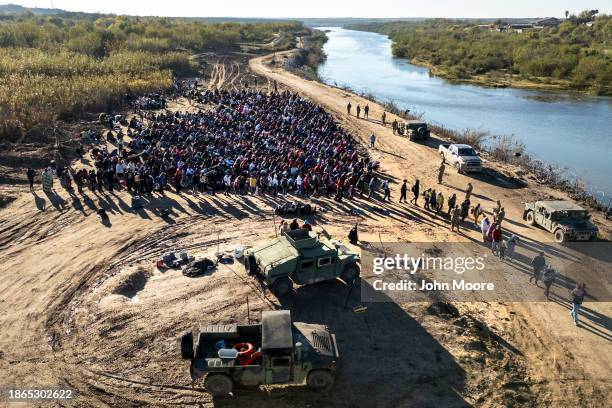 In this aerial view, Texas National Guard troops direct a group of more than 1,000 immigrants towards a U.S. Border Patrol processing center after...