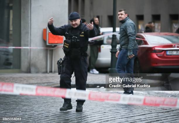 Police officer stands at a cordon around the location of the shooting on December 21, 2023 in Prague, Czech Republic. A shooting leaves several dead...