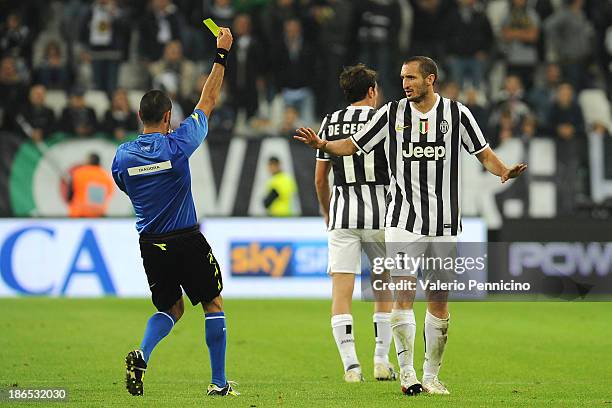Giorgio Chiellini of Juventus receives the yellow card from referee Marco Guida during the Serie A match between Juventus and Catania Calcio at...