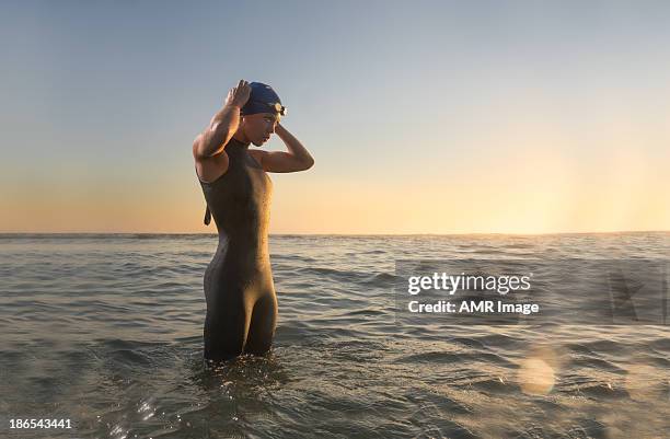 female triathlon athlete at sunrise - triathlon stock pictures, royalty-free photos & images