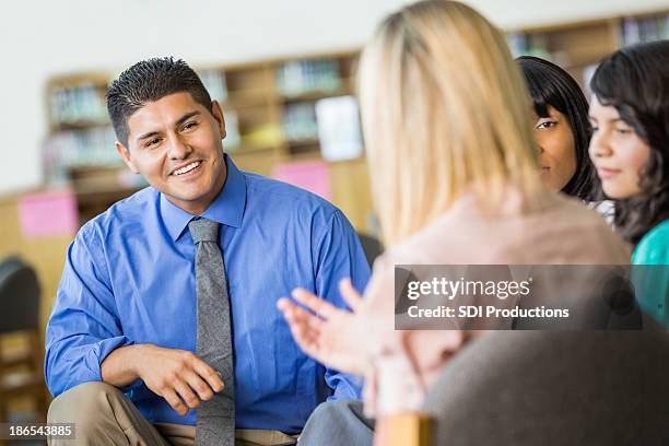 hispanic counselor discussing something during group therapy session - male group therapy stock pictures, royalty-free photos & images