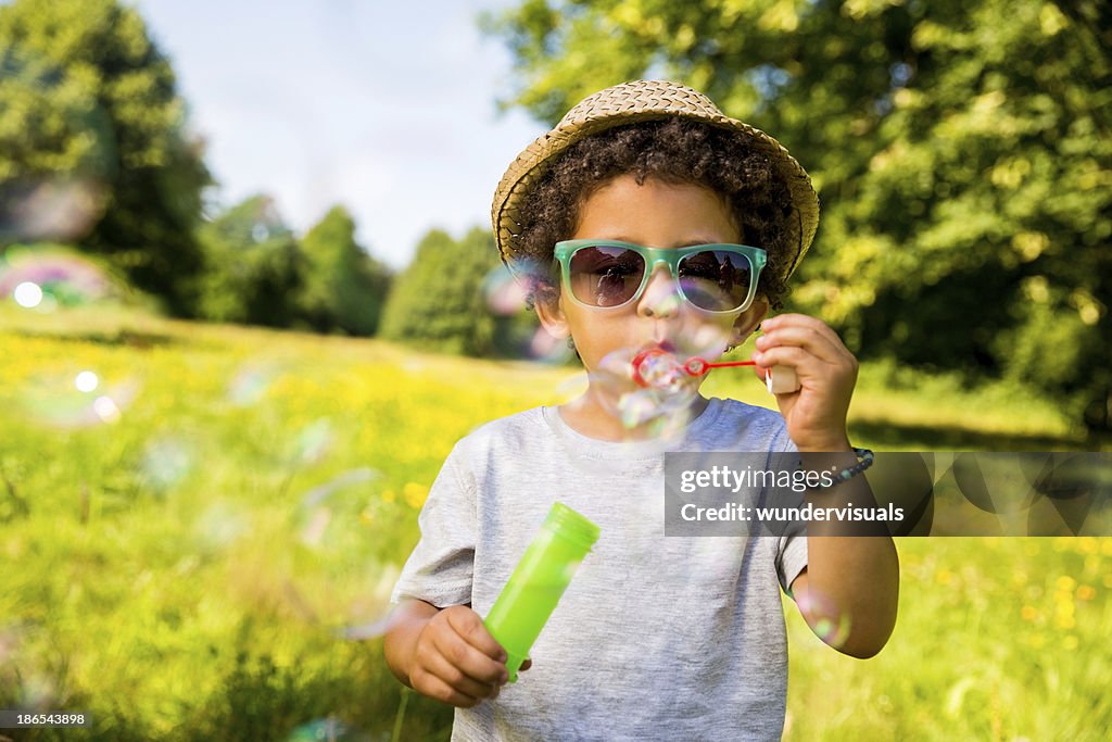 Child blowing bubbles in park