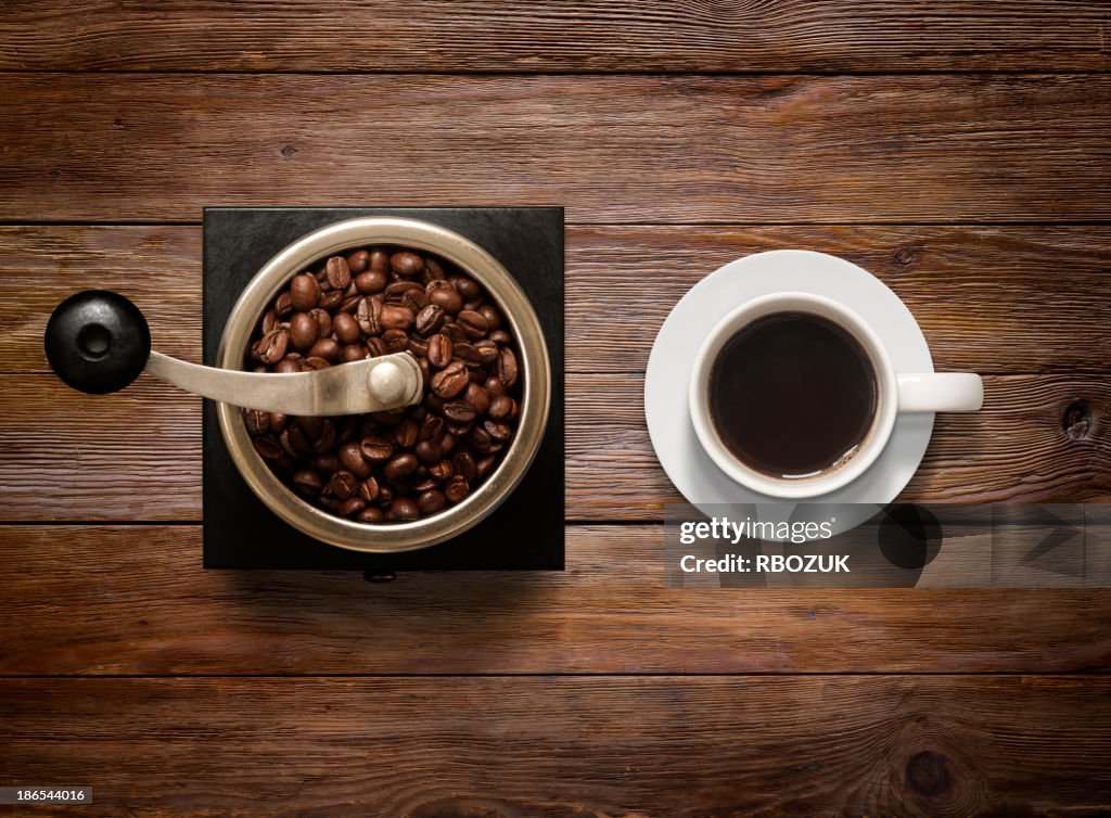 Overhead shot of Coffee Cup and Grinder on Wooden Background