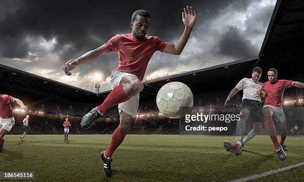 soccer player controlling ball in mid match action - football player stock pictures, royalty-free photos & images