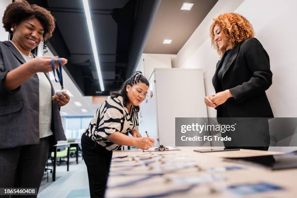 business conference participants registering for a conference - anmelden stock-fotos und bilder