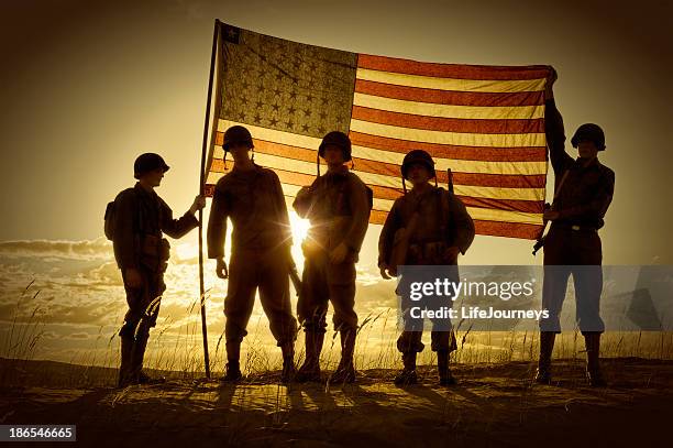 silhouette of soldiers with american flag - us army stockfoto's en -beelden