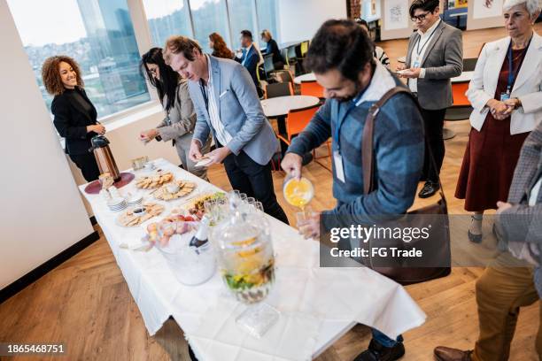 business people getting food during conference coffee break - mittagessen stock-fotos und bilder