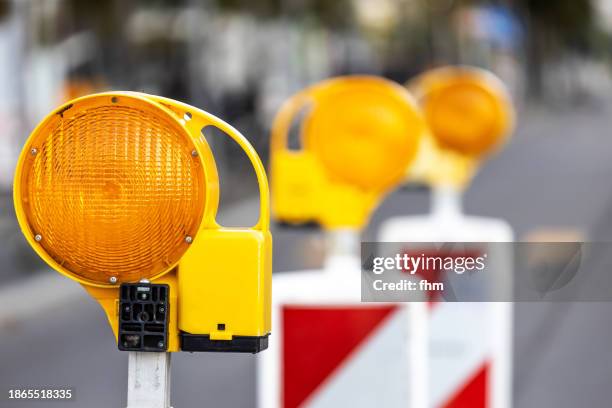 three yellow warning lights at a construction site on the street - construction barrier stock pictures, royalty-free photos & images