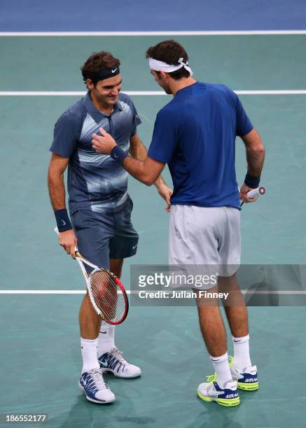 Juan Martin Del Potro of Argentina and Roger Federer of Switzerland enjoy a moment as they end up on the same side of the court during day five of...