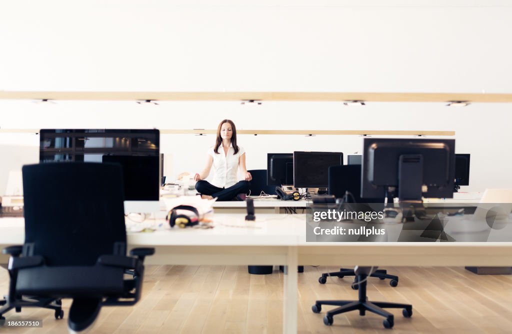 Businesswoman doing yoga at the office