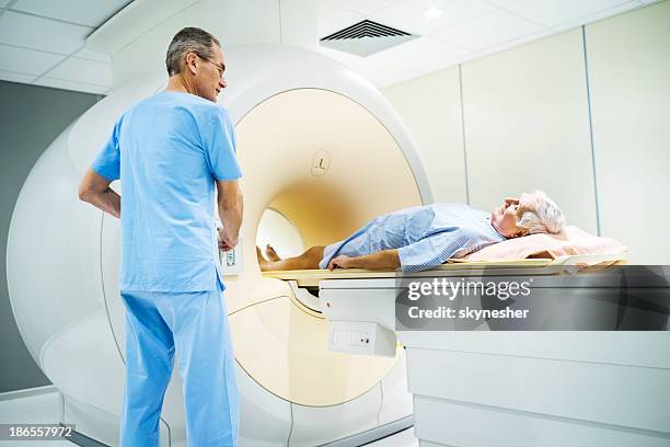 senior erhalten ein magnetresonanztomographie. - cat scan machine stock-fotos und bilder