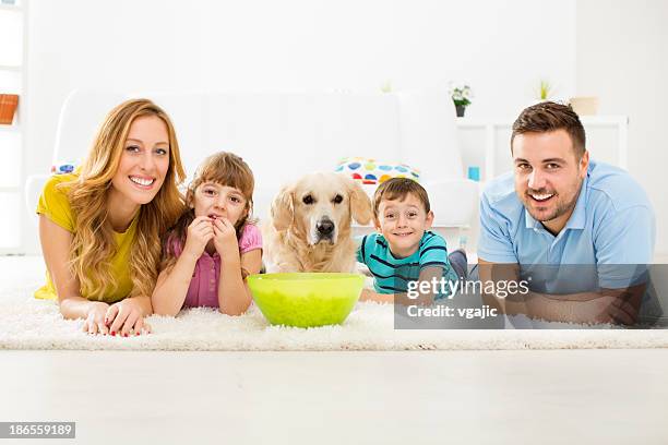 cheerful family eating popcorns and watching tv. - family tv pet stock pictures, royalty-free photos & images