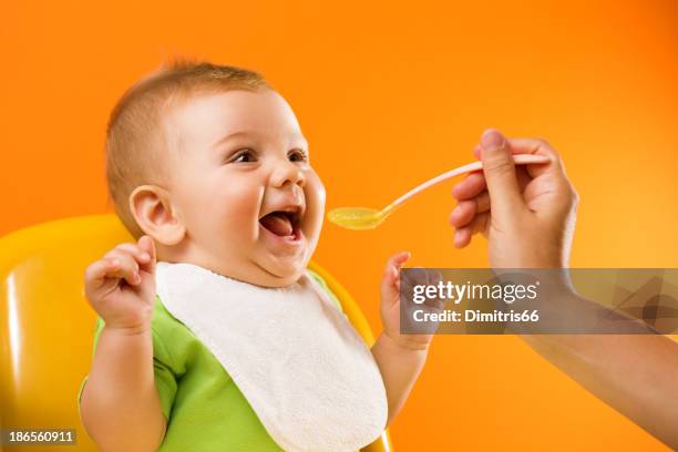 feeding excited baby - baby bib stock pictures, royalty-free photos & images