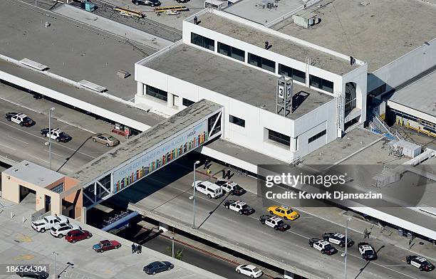 Los Angeles Police Department officers patrol on the roof and the ground while investigating a shooting at Terminal 3 of Los Angeles International...