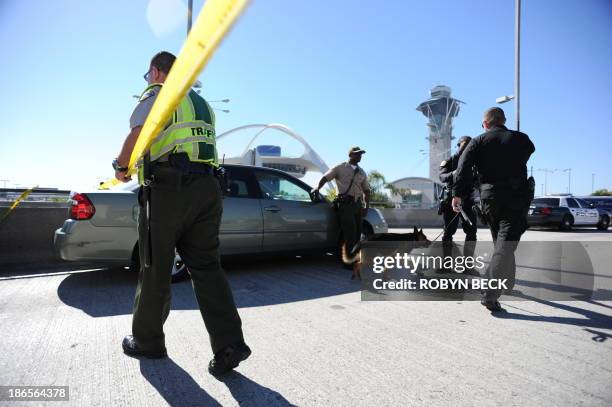 Poli e officers provide security on November 1, 2013 after a gunman reportedly opened fire at a security checkpointin Los Angeles International...