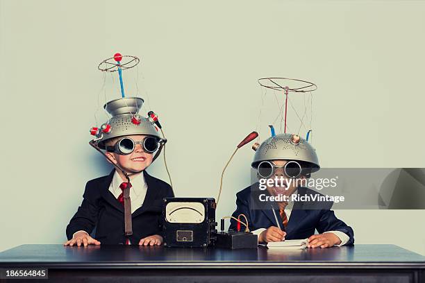 boys vestido como empresarios usando cascos mente de lectura - studio workplace fotografías e imágenes de stock