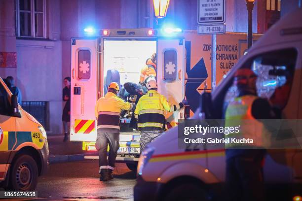 Paramedics load a stretcher into an ambulance van at the location of the shooting on December 21, 2023 in Prague, Czech Republic. A shooting leaves...