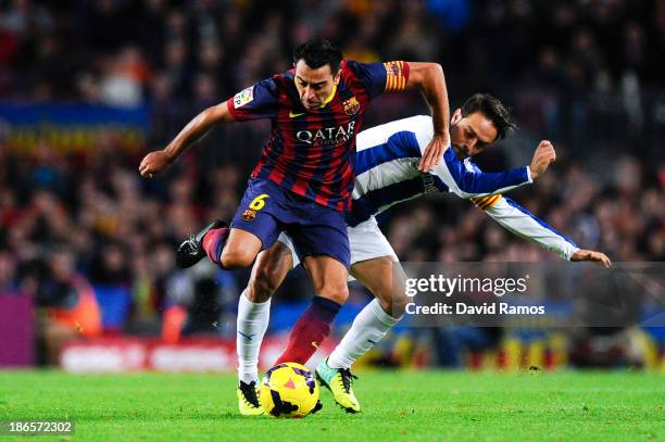 Xavi Hernandez of FC Barcelona duels for the ball with Sergio Garcia of RCD Espanyol during the La Liga match between FC Barcelona and RCD Espanyol...