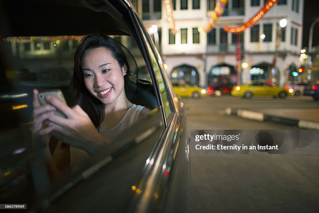 Chinese woman in car with smartphone