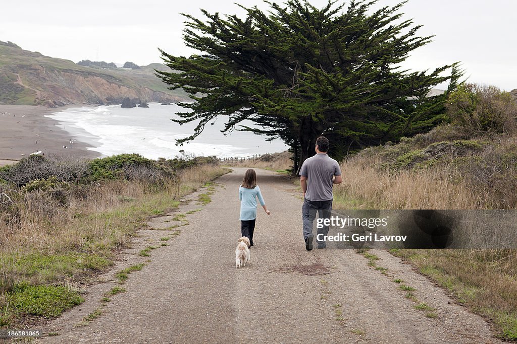 Father and daughter walking their dog