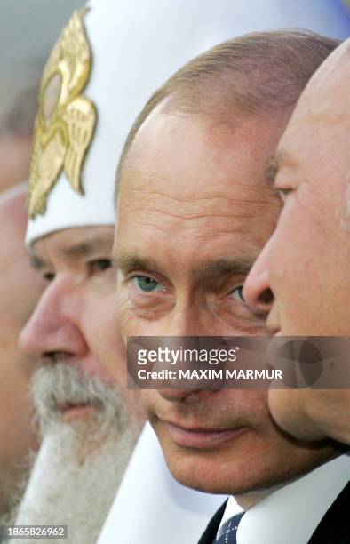 Russian President Vladimir Putin speaks with Moscow's Mayor Yuri Luzhkov as Russian Orthodox Patriarch Alexi II sits next to them during the Day of...