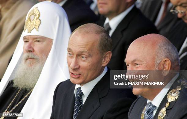 Russian President Vladimir Putin speaks with Moscow's Mayor Yuri Luzhkov as Russian Orthodox Patriarch Alexi II sits next to them during the Day of...